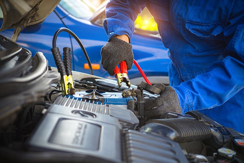 A service tech doing an oil change a car